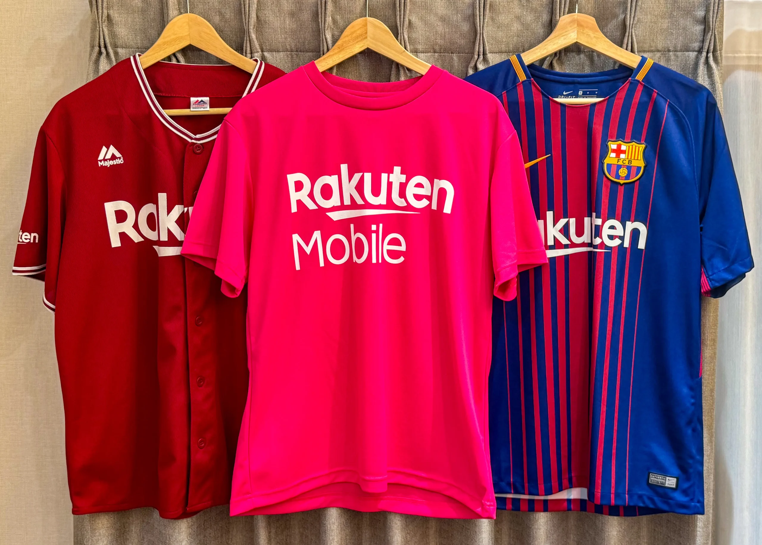 楽天モバイルのピンクTシャツと楽天イーグルス・FCバルセロナのユニフォームが並ぶ、楽天グループのスポンサー活動を示す画像