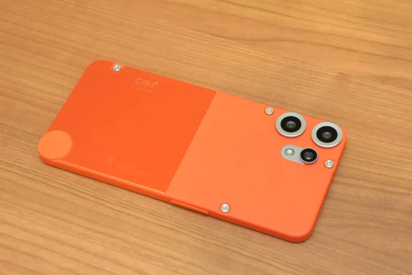 CMF Phone 2 Pro背面オレンジモデル。ツートーン仕上げと露出したネジが映える独創的デザインを斜め上から撮影