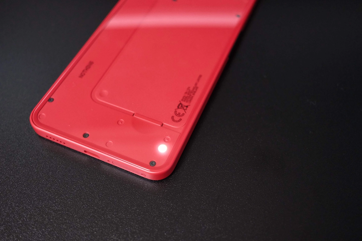 Nothing Phone (3a) Lite レッドの背面下部でGlyphライトが点灯している様子
