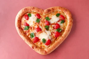 ピザーラの期間限定メニュー「ハートピザ」。トマト、バジル、フレッシュチーズが乗ったハート型のマルゲリータピザ。 